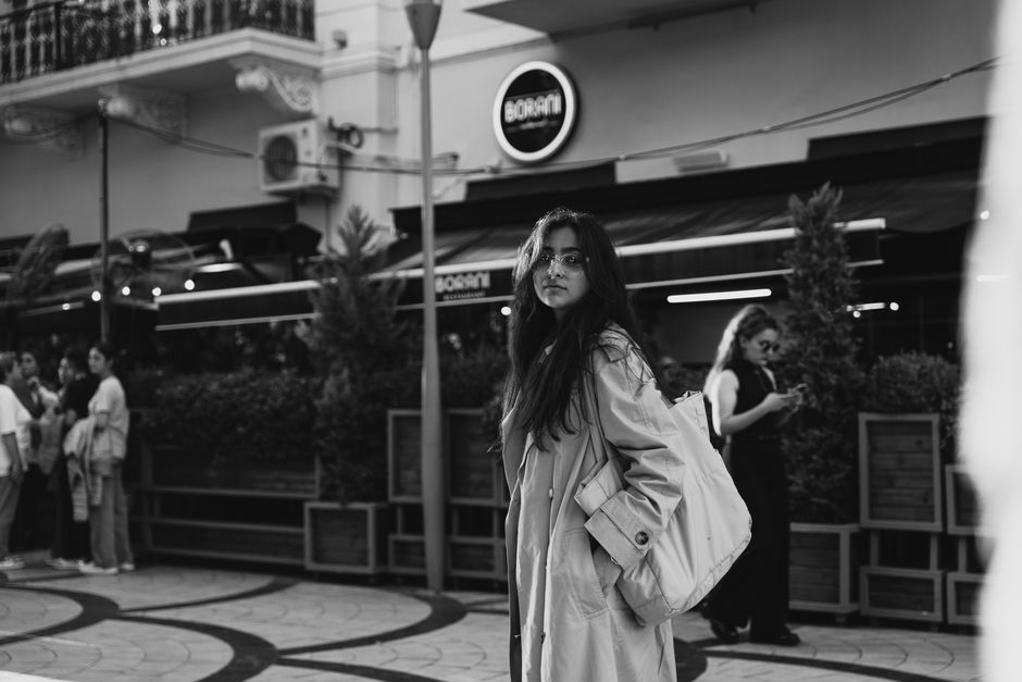 A black and white portrait of a young woman in Baku, Azerbaijan street setting, creates a