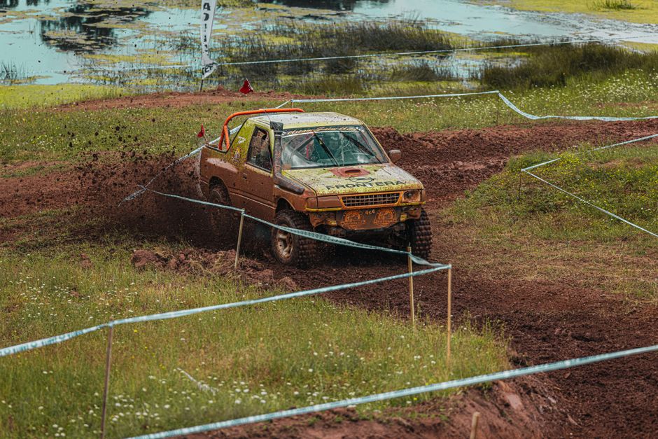 An off-road vehicle splashing through muddy terrain during a thrilling race event.