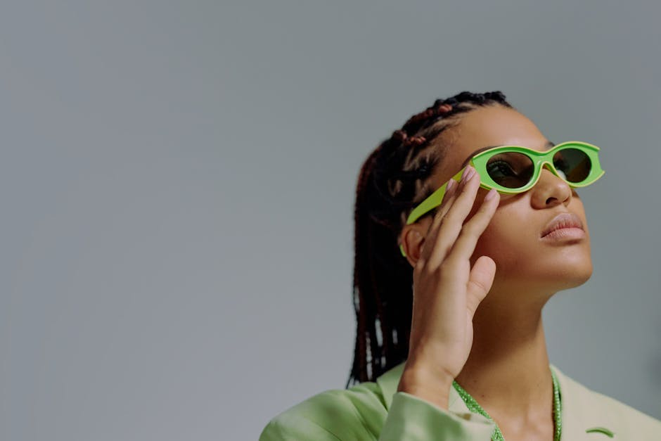 Elegant studio portrait of a woman wearing bold green sunglasses, exuding chic fashion vibes.