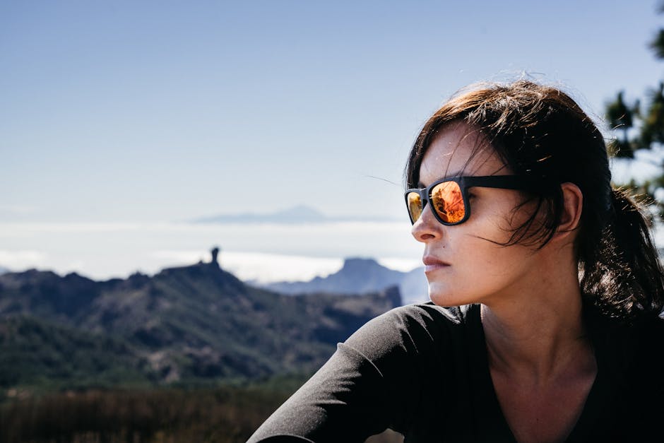 Adult woman wearing sunglasses gazing at Gran Canaria's landscape.