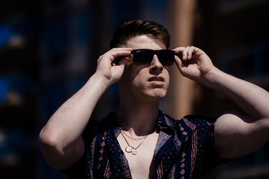 Elegant adult man in sunglasses enjoys a bright and sunny day outdoors.