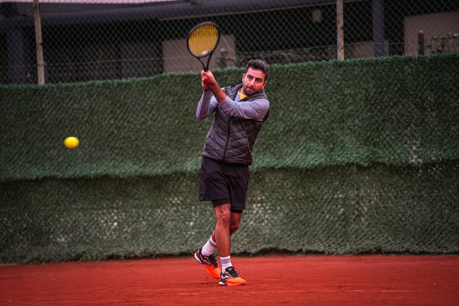 A focused male player practicing tennis on a clay court in Altinoluk, Türkiye.