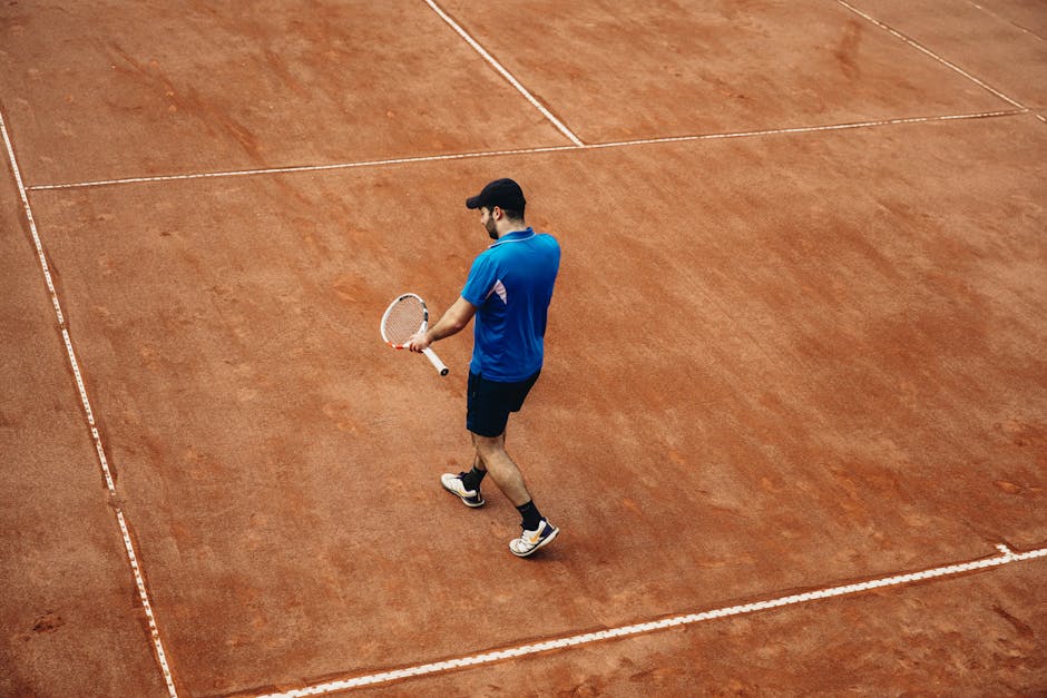 Athlete holding tennis racket on a clay court, summer sports action