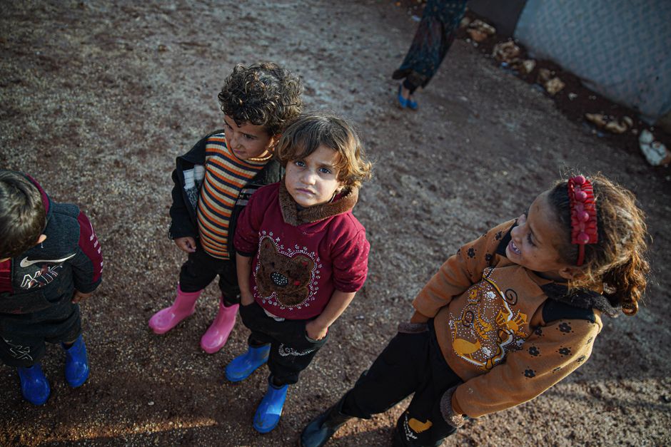 A group of children playing outdoors in Idleb, Syria, showcasing resilience and innocence.