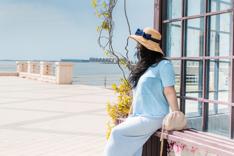 Woman enjoying a sunny day in Baku with a sea view.