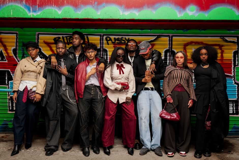 Fashionable group of adults posing in front of a vibrant graffiti wall, expressing diverse