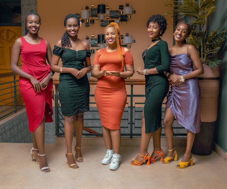 Five fashionable women in stylish dresses posing indoors, exuding confidence and elegance.